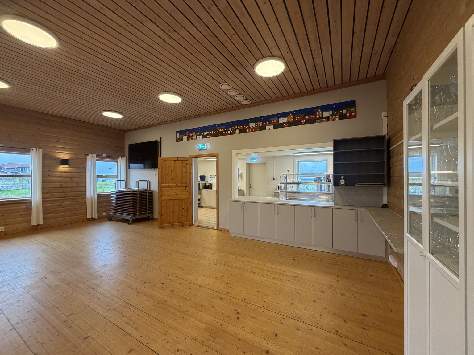 Restauranten med tregulv, serveringsdisk og åpning inn mot kjøkkenet