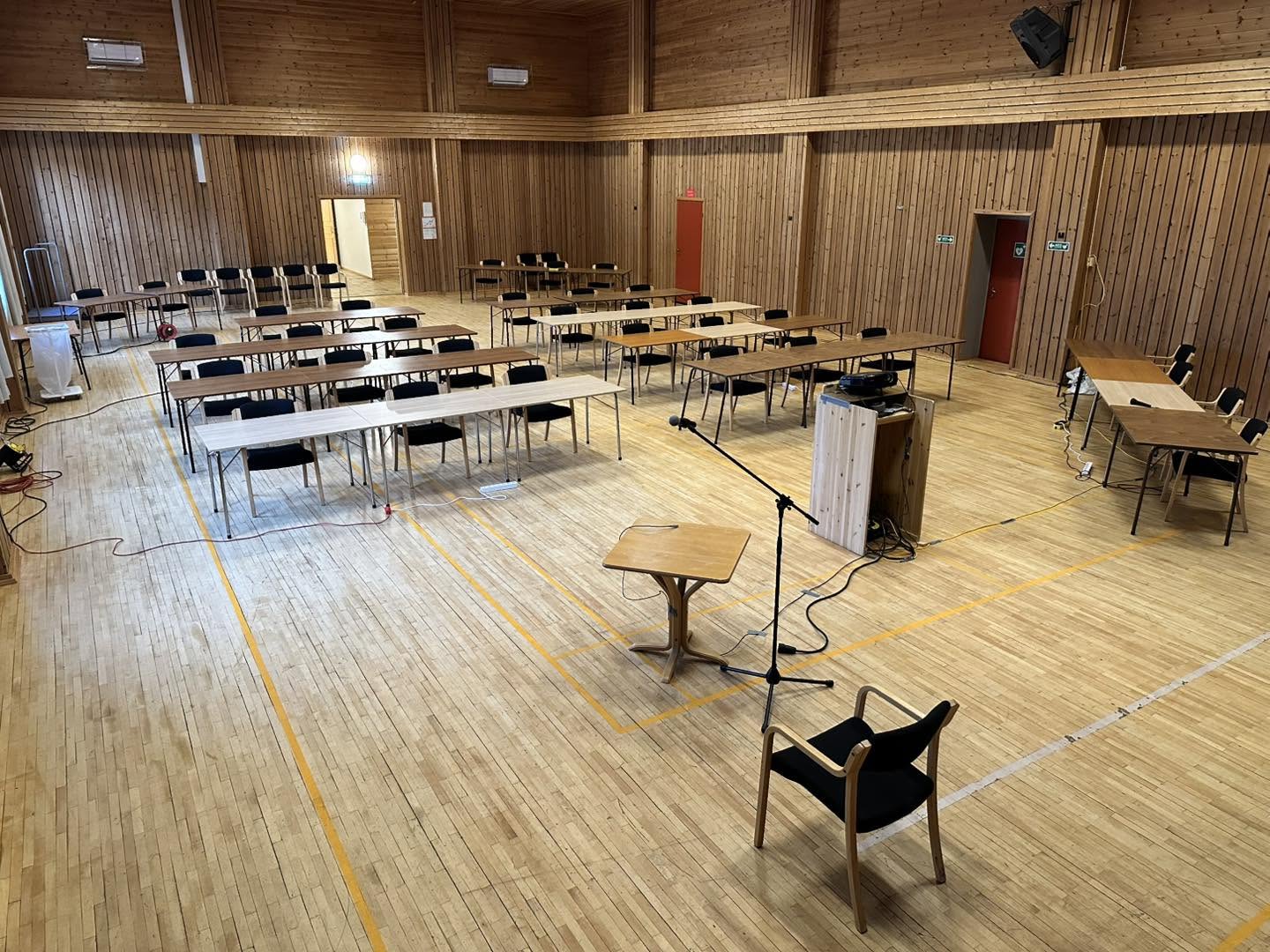 Storsalen med bord i rekker, stoler og mikrofon til kurs